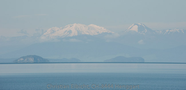 Blick über den Lake Taupo zu den Gipfeln Mt. Tongariro, Mt. Ngauruhoe und dem Mt. Ruapehu (Nordinsel).